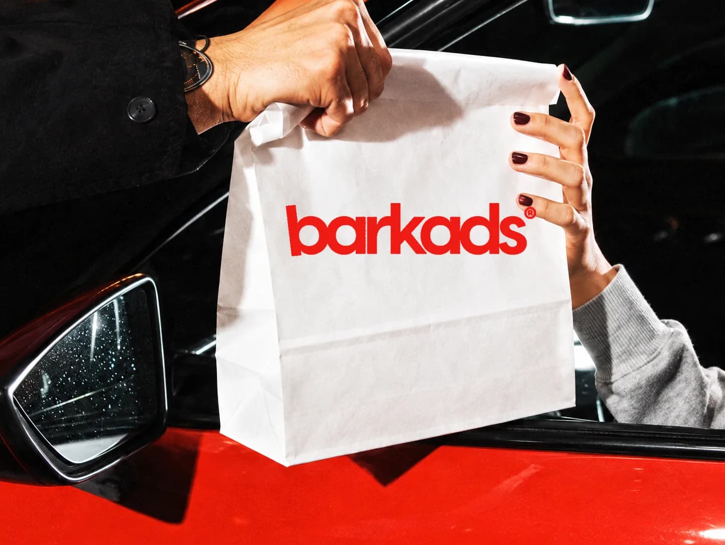 Bolsa de takeaway entregada junto a un coche rojo